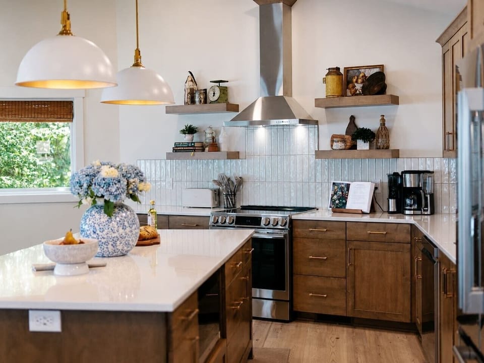 Thoughtful finishes, layered lighting, and a full-size range make the kitchen feel polished while remaining practical for group meals.