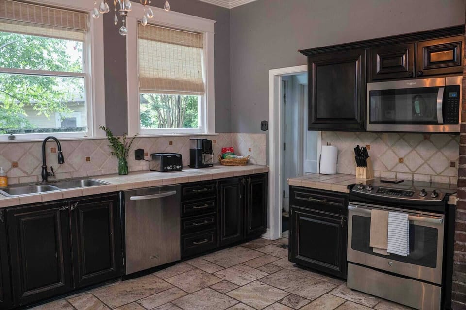 Kitchen with a gas range, dishwasher, and stone tile floor
