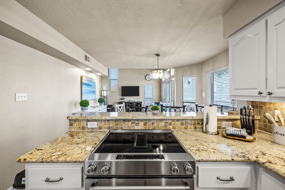 The open-concept kitchen keeps the cook connected to the gathering spaces—perfect for preparing meals while spending time together and enjoying Gulf views