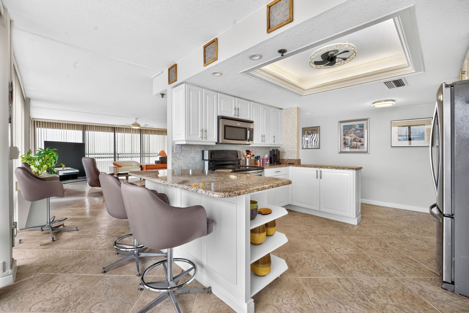 You'll love gathering around the spacious granite island for breakfast or casual meals. Sleek white cabinetry, modern appliances, and a breezy open layout make your stay feel effortless.