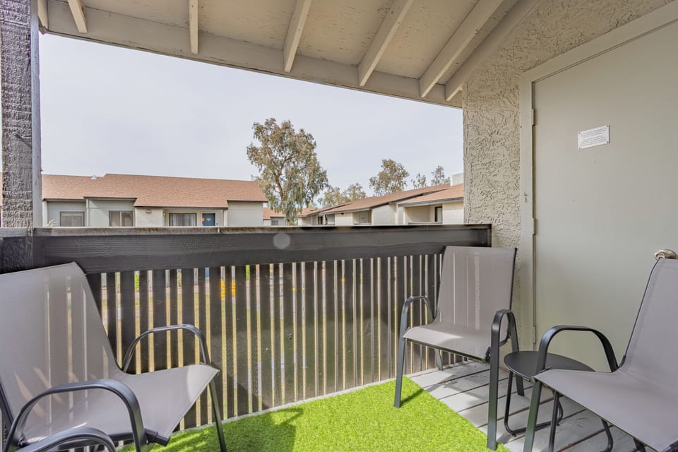 Private balcony with chairs and green turf for a peaceful outdoor retreat.