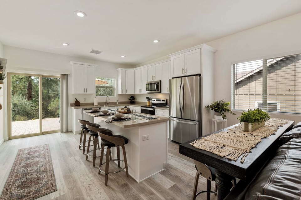 Bright, open kitchen with bar seating & peaceful views of the surrounding pines.