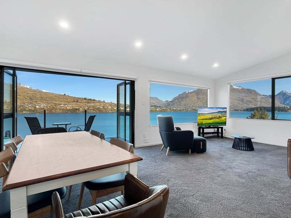 Open-plan living and dining area with floor-to-ceiling windows showcasing spectacular lake views.