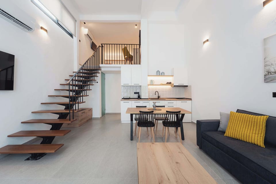Spacious living room with contemporary furnishings, high ceilings, and plenty of natural light. The open layout offers a relaxing atmosphere where everyone can gather, dine, or unwind in complete comfort