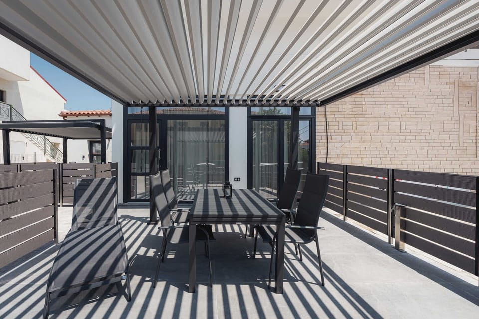 Enjoy outdoor living on the spacious covered terrace, complete with comfortable seating and a dining area. The pergola provides shade throughout the day, making it an ideal place for breakfast, dinner, or evening drinks