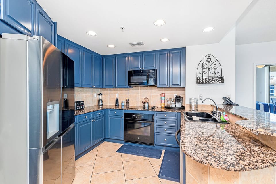 Your fully-equipped kitchen features striking blue cabinetry, granite countertops, and stainless steel appliances—everything you need to cook and gather with ease.