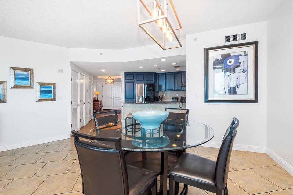 Gather around the glass dining table for meals with coastal charm, as ocean-hued art and a fully equipped kitchen await your culinary adventures.