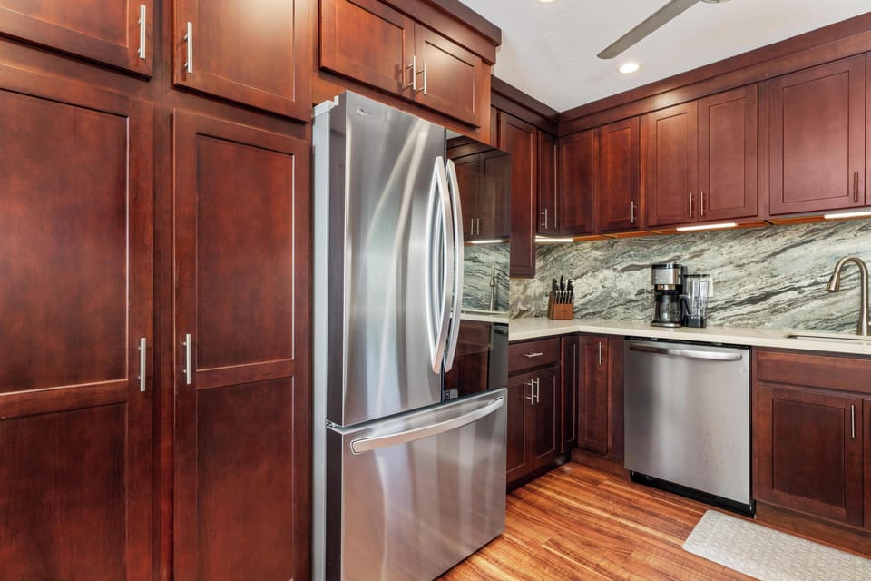 Cook your favorite meals in this beautifully appointed kitchen, featuring rich wood cabinetry, sleek stainless steel appliances, and elegant granite countertops that make every moment feel luxurious.