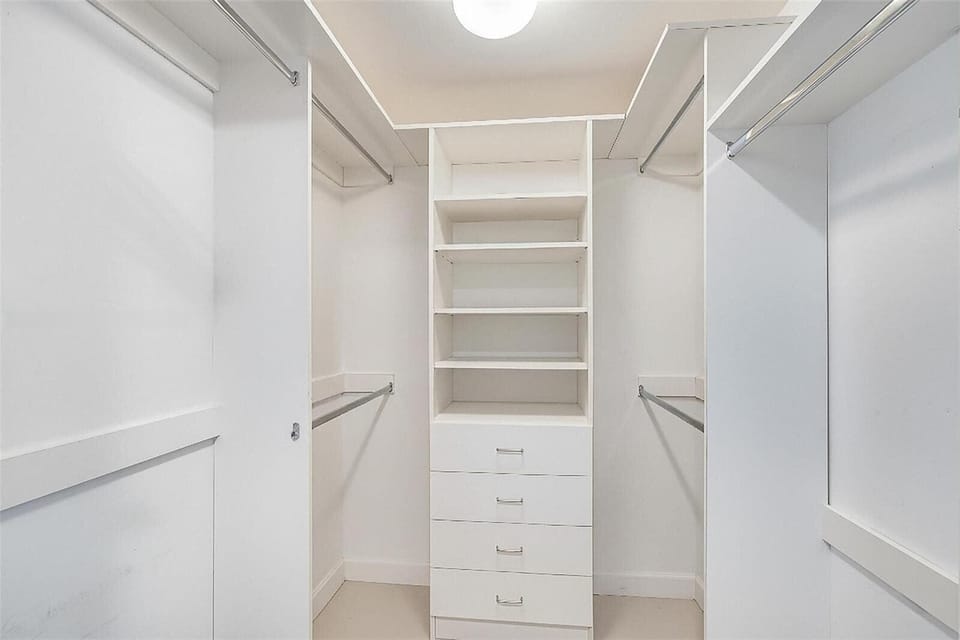 Spacious walk-in closet with built-in shelving, drawers, and plenty of hanging space — unpack and settle in with ease.