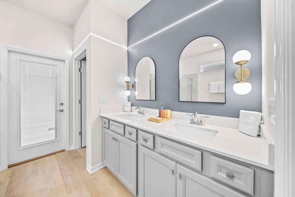 Experience a beautifully designed bathroom with elegant gray cabinetry and dual sinks for ample space during your morning routine.