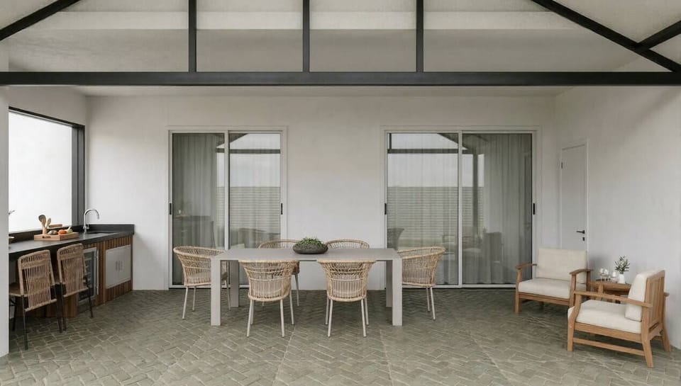Discover a stylish dining area filled with natural light, featuring a sleek wooden table and airy rattan chairs. Large glass doors create a seamless flow to the outdoors, while the minimalist decor adds to the relaxing atmosphere.