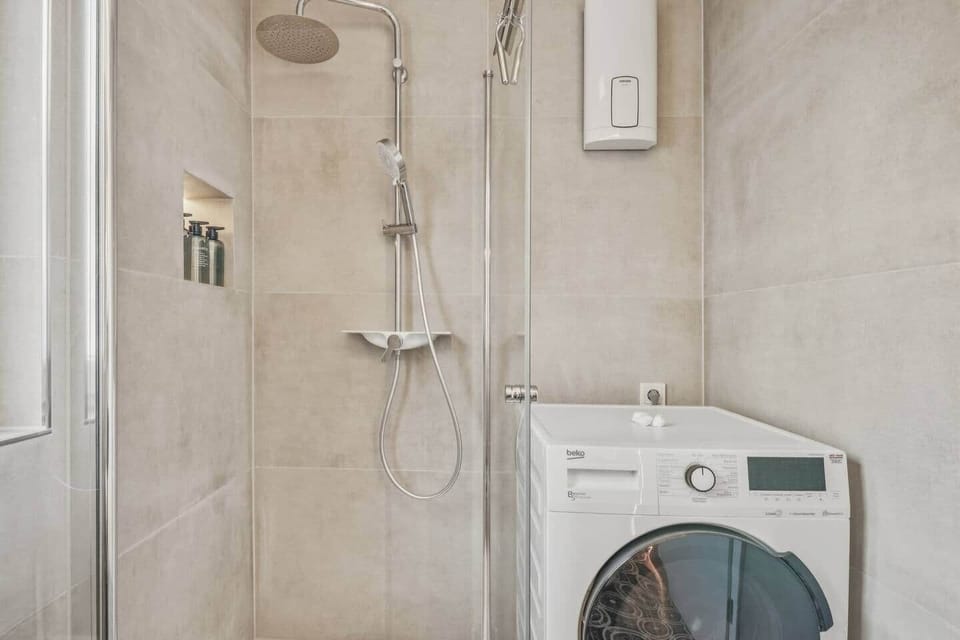 Moderne Dusche mit eigenem Waschtrockner – praktischer Komfort für euren Aufenthalt in Trier

