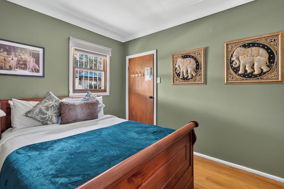 Unwind in the primary bedroom with a queen bed, built-in wardrobes and a curated bookshelf inviting you to settle in with a good read before bed.