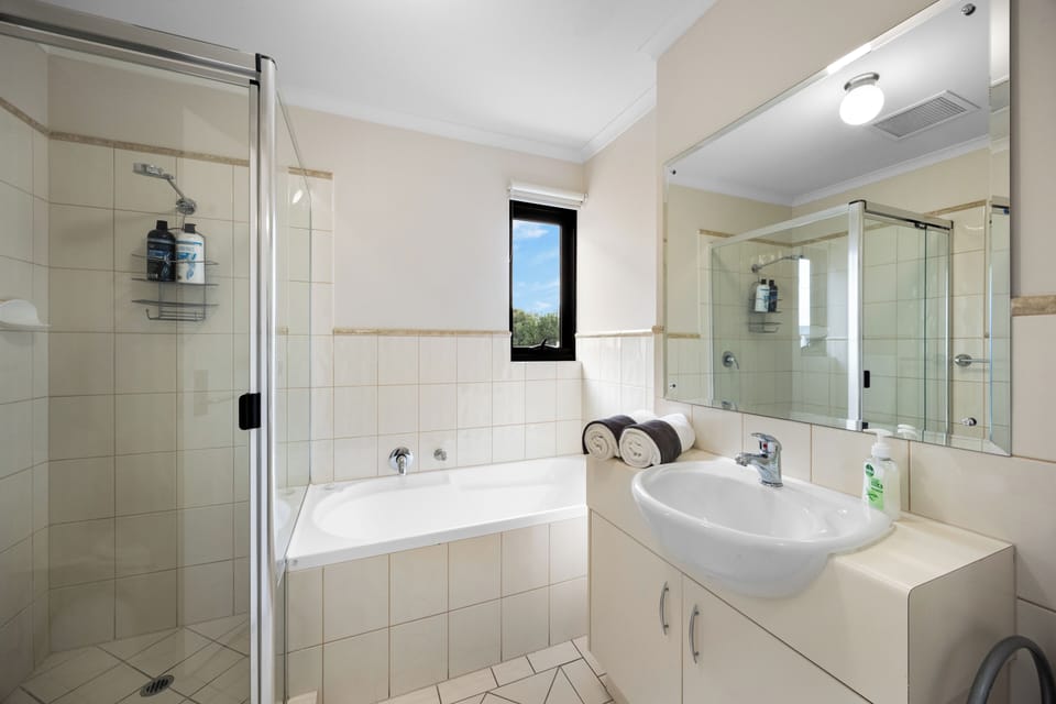 Freshen up in the main bathroom, where a separate bath and shower offer flexibility whether you're soaking after a day of sightseeing or rinsing off after the beach.