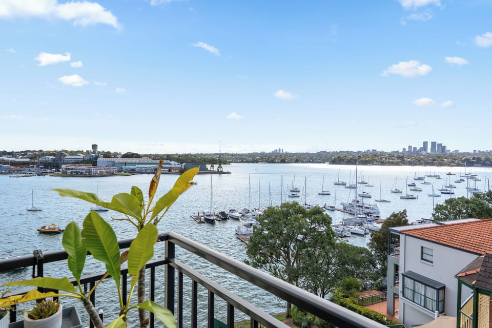 Watch Sydney's waterfront come to life as ferries, sailboats, and shimmering water create a spectacular outlook towards Cockatoo Island.
