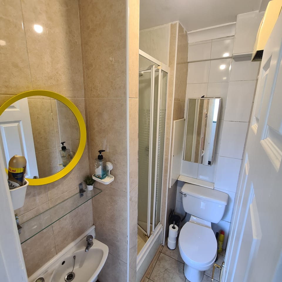 Bright tiled bathroom with glass shower and clean, practical layout