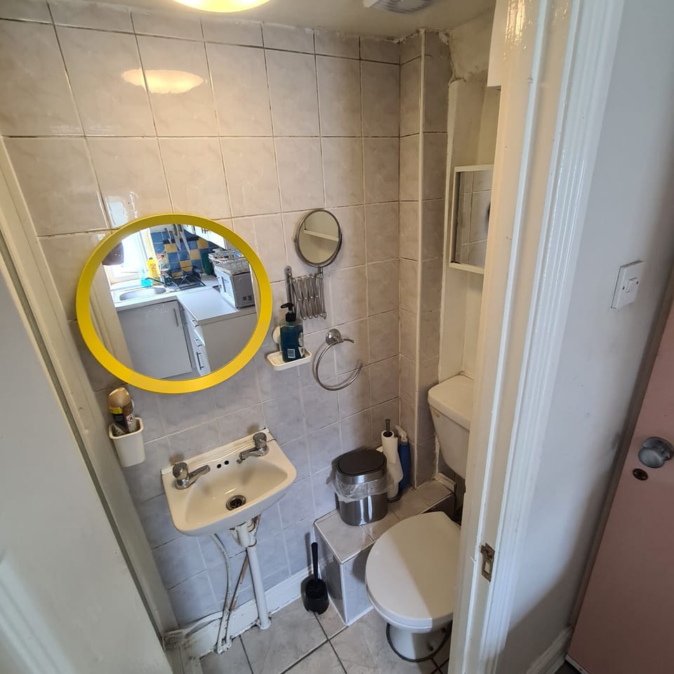 Compact tiled bathroom with bright, clean finishes and essential amenities
