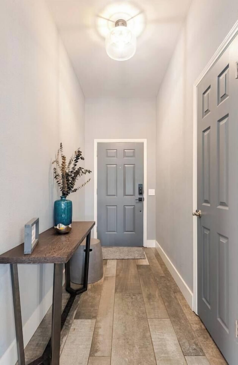 Feel welcomed into a stylish entryway featuring a sleek console table, modern decor, and warm lighting. This inviting space sets the tone for a comfortable and memorable stay in your cozy home away from home. 