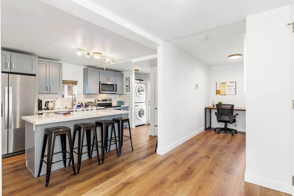 Bright, open layout combines a fully equipped kitchen, island seating and dedicated work area.
