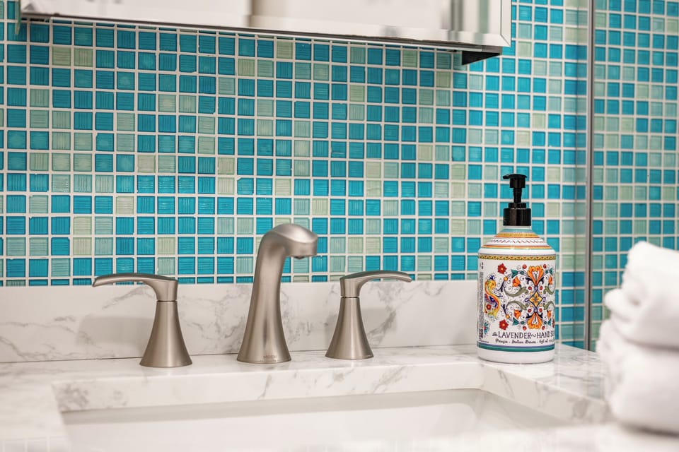 Elegant bathroom vanity with marble finishes and vibrant blue tile