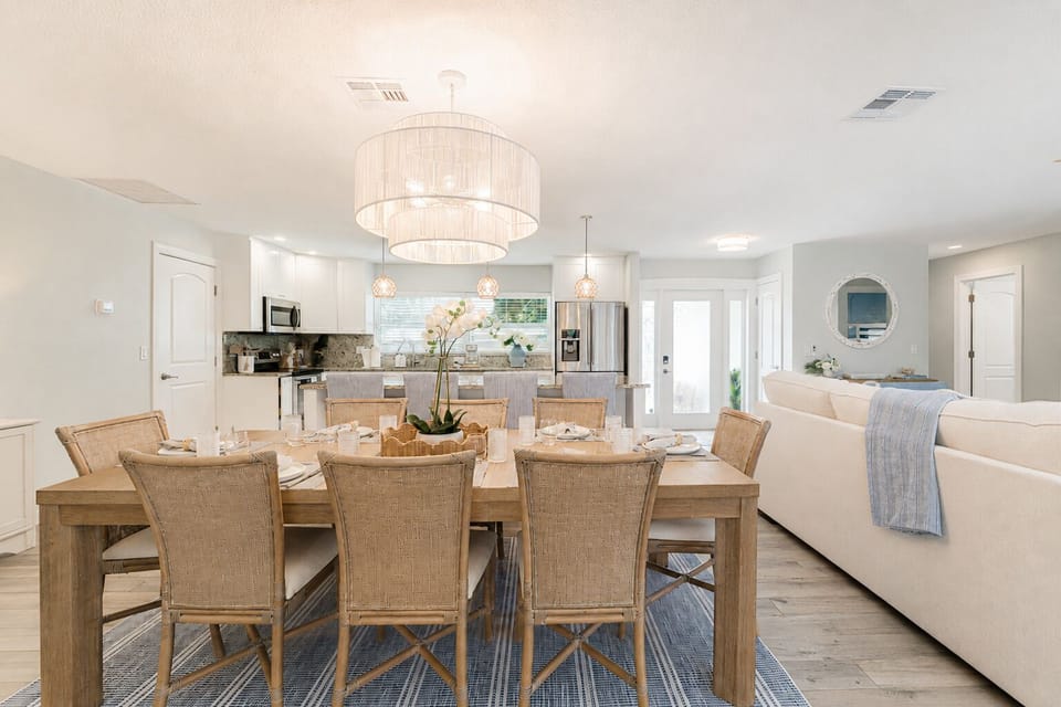Share unforgettable meals around the spacious dining table with seating for eight, while the oversized kitchen island provides seating for four more. Whether it's a family dinner, holiday celebration, or casual brunch, this bright, coastal-inspired space c