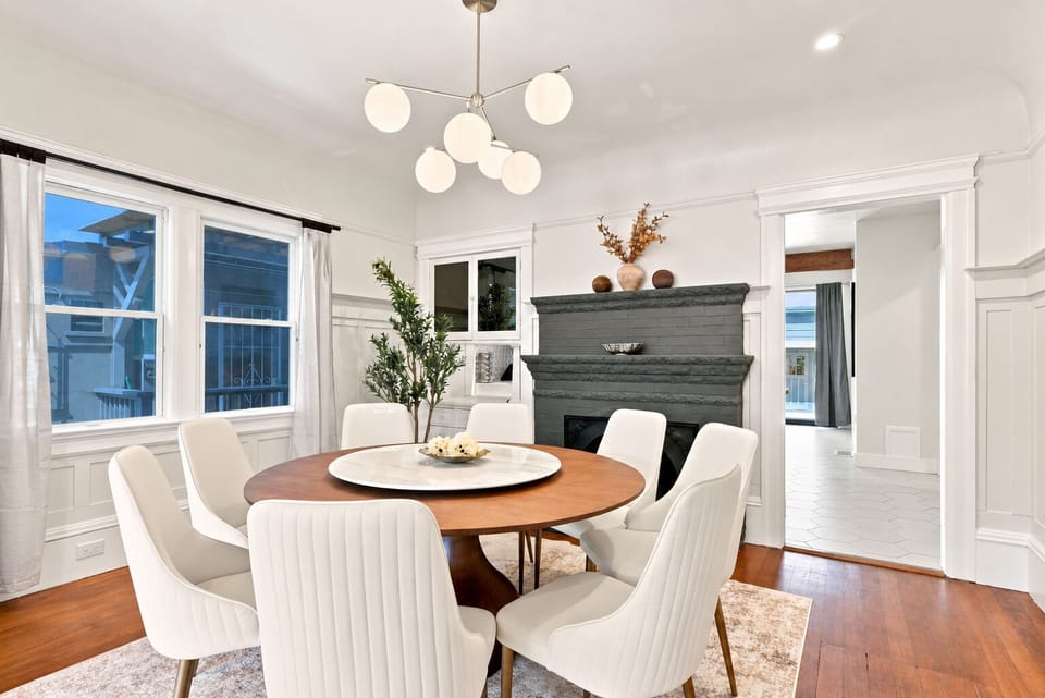 Elegant dining room with fireplace, natural light, and seating for six