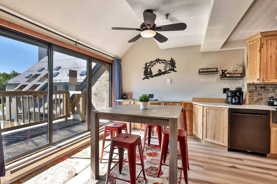 Mountain scenery frames the dining table through the wide balcony doors.