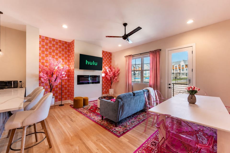 Gather around the dining table for meals, game nights, or a toast before heading out. The open layout keeps everyone connected while adding a vibrant pop of Rosé style.