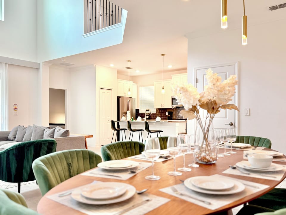 Beautiful open dining space with tableware, wine glasses & seamless kitchen view