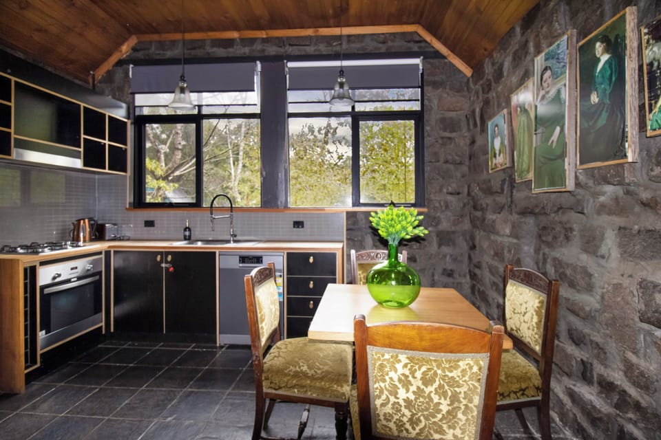 Rustic stone kitchen with sunny dining nook and scenic window views