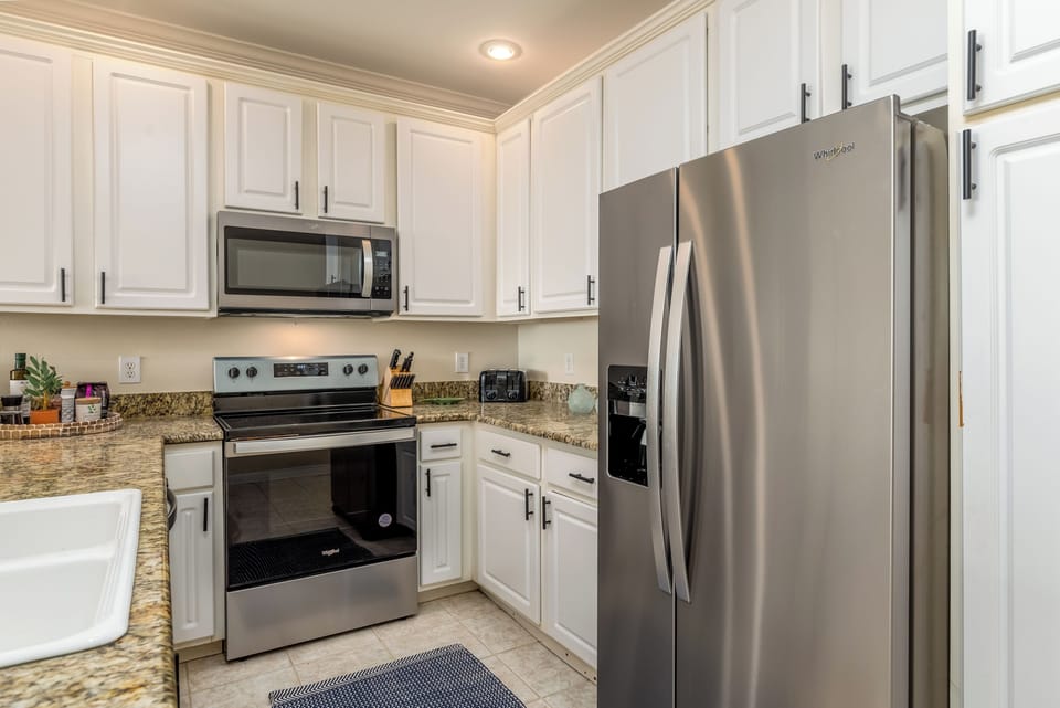Cook your favorite meals in this bright, fully equipped kitchen with granite counters and stainless steel appliances.
