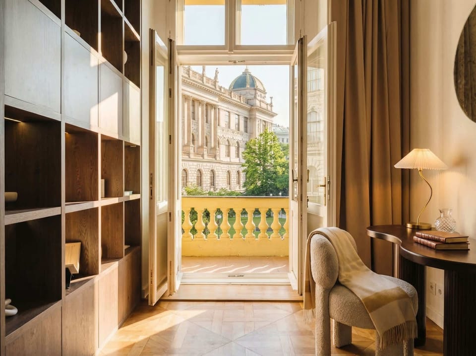 Bedroom with balcony access and large windows overlooking the National Museum, one of the most iconic seeing in Prague. Natural light, comfortable bed, and a quiet spot to relax.
