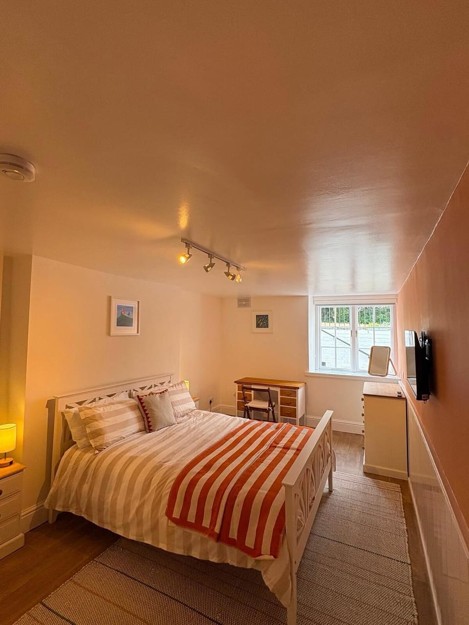 A king size bed with wardrobe chest of draws full length mirror and desk/chair