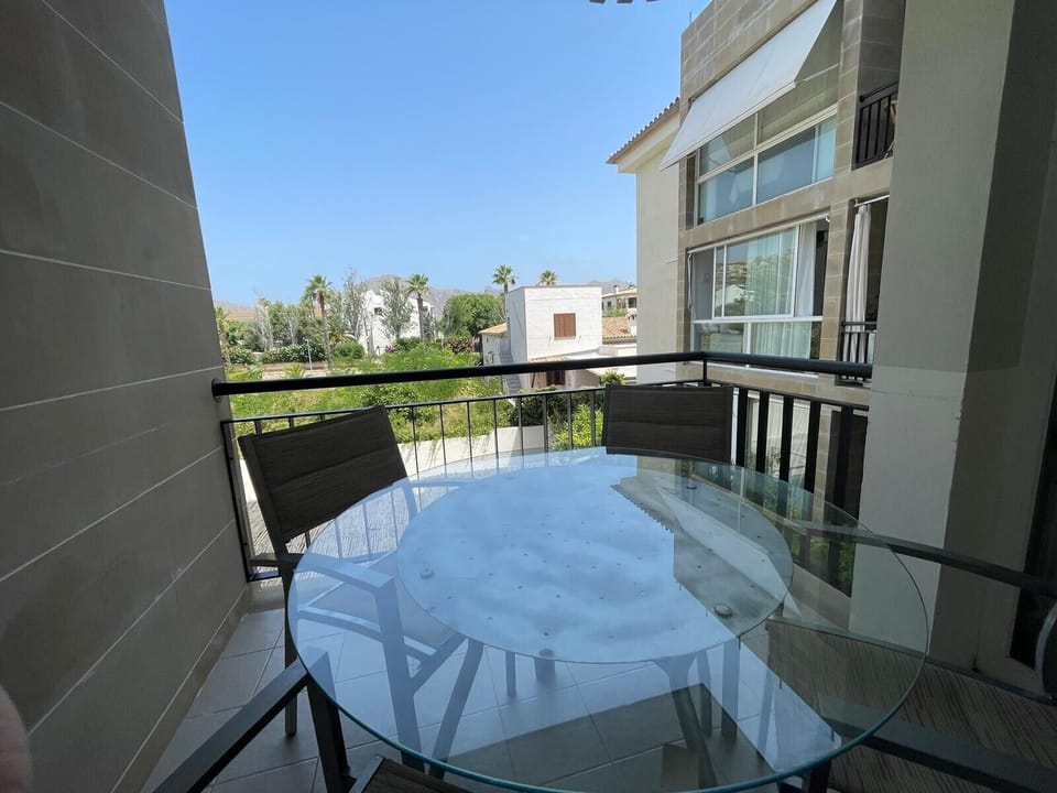 Covered private terrace with an outdoor dining table for four and pleasant views of the gardens and mountains, ideal for relaxing or dining outside.