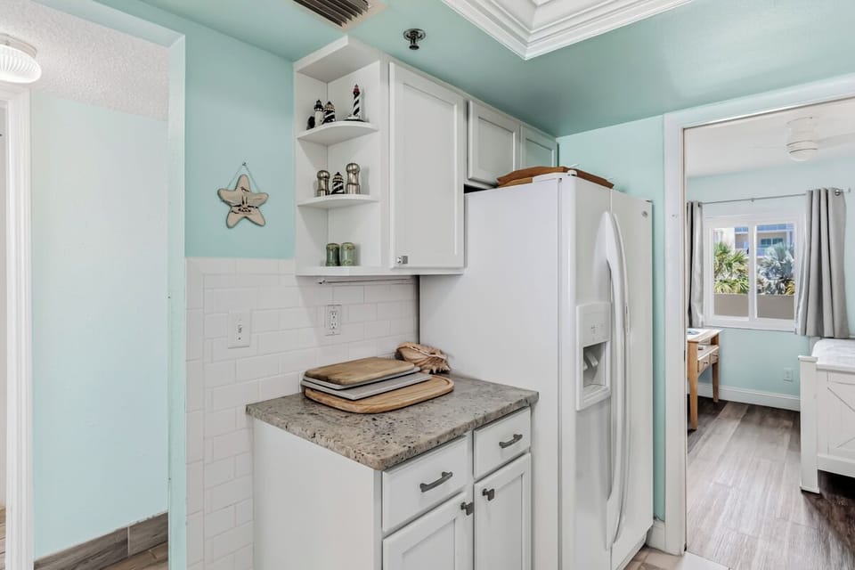 Step into your bright coastal kitchen, where soft aqua walls and white cabinetry create a serene beachy vibe. Fresh, functional, and inviting—your perfect home base for morning coffee.