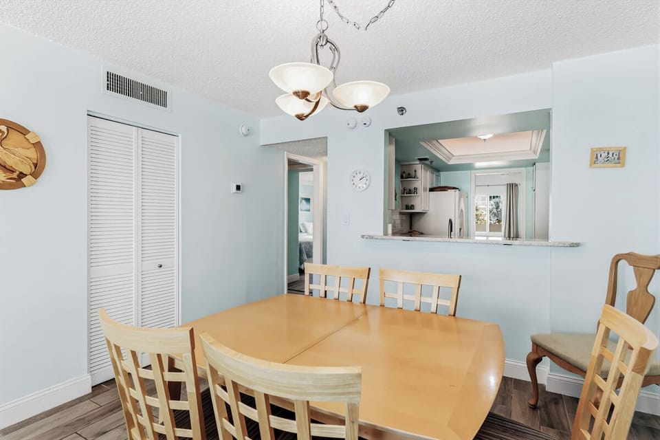Gather around this spacious dining table where your group can enjoy home-cooked meals together, with easy access to the open kitchen through the convenient serving window. Light-filled and welcoming.