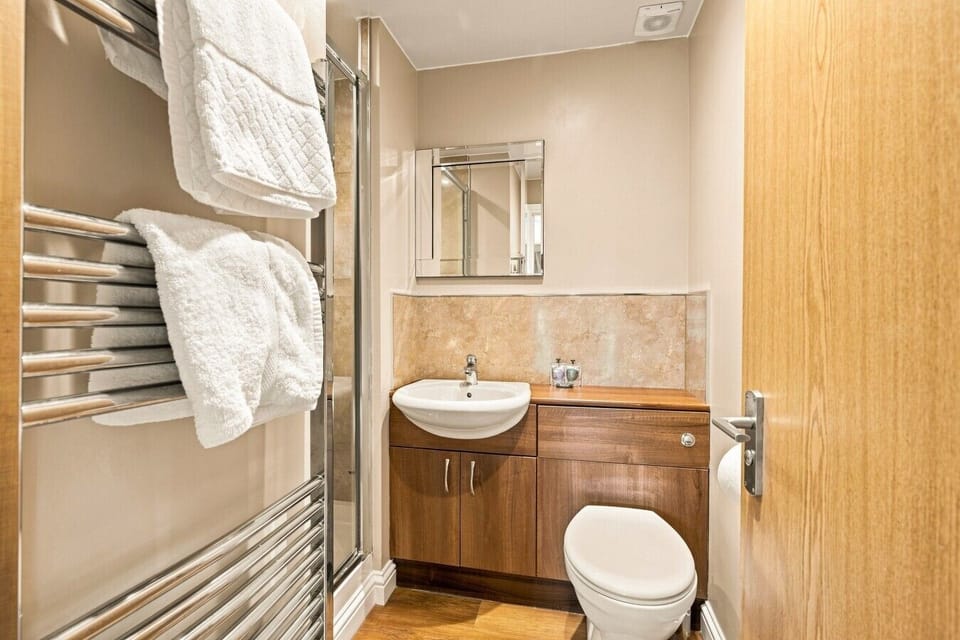En-suite shower room with vanity unit, heated towel rail and mirror.