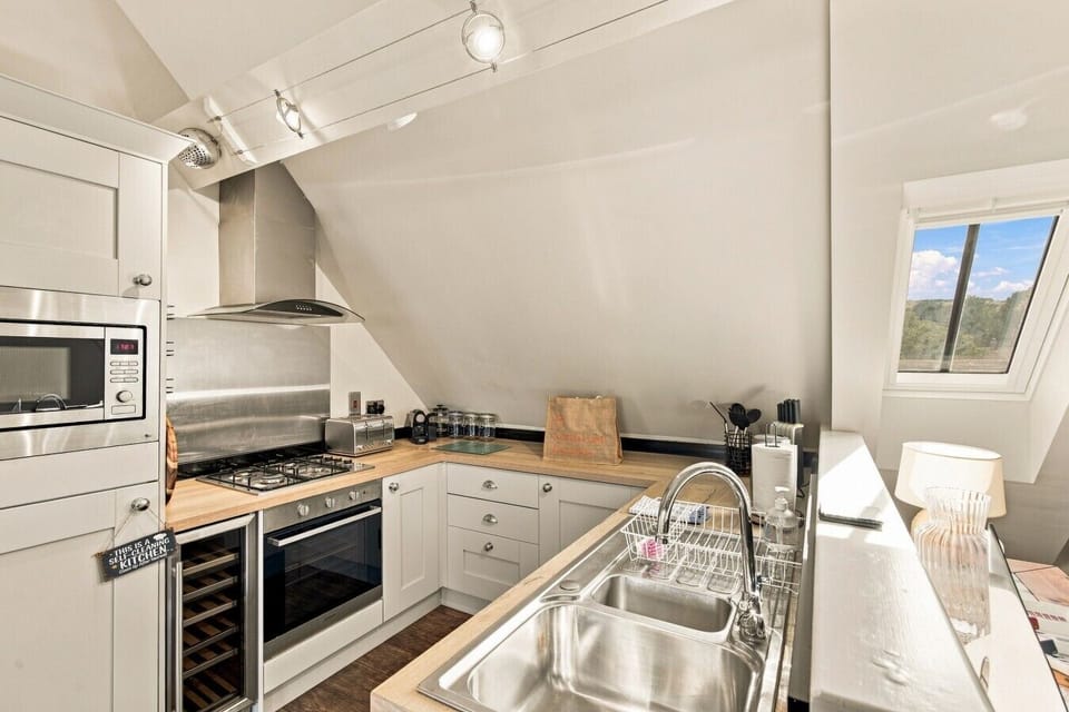Contemporary kitchen with skylight, breakfast bar and integrated appliances.