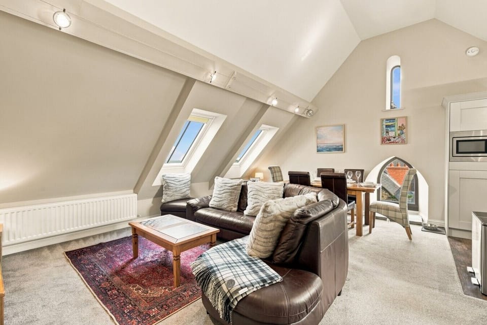 Open-plan living area with skylights, leather sofas and dining space.