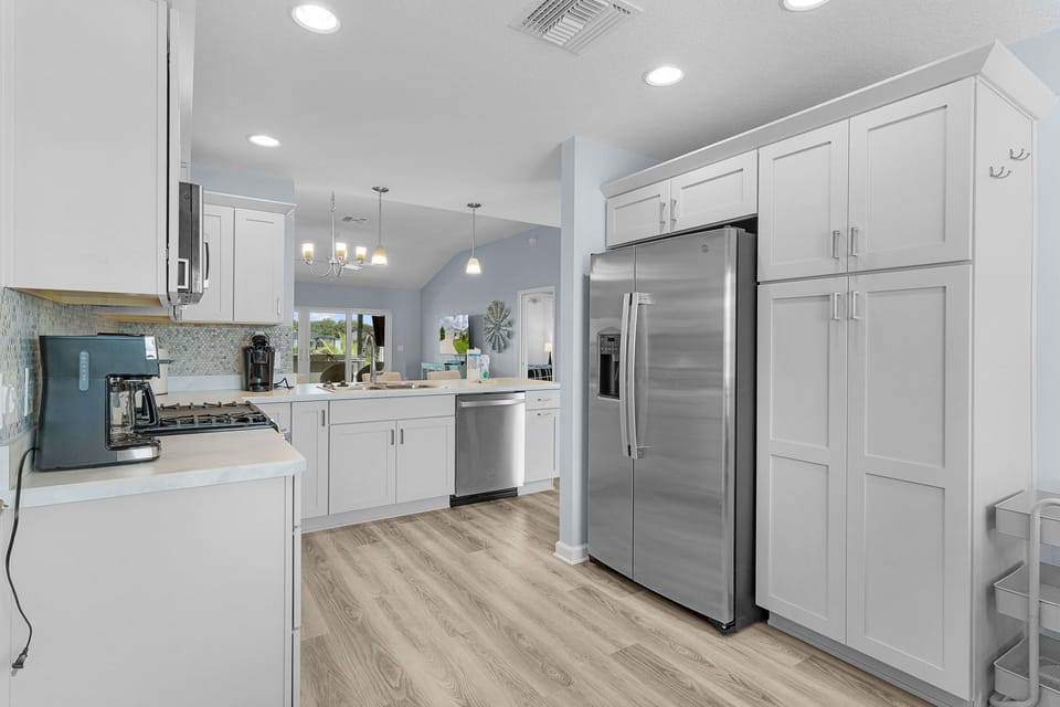 Step into your fully equipped kitchen with sleek white cabinetry, stainless steel appliances, and ample counter space—perfect for whipping up your favorite meals during your stay.