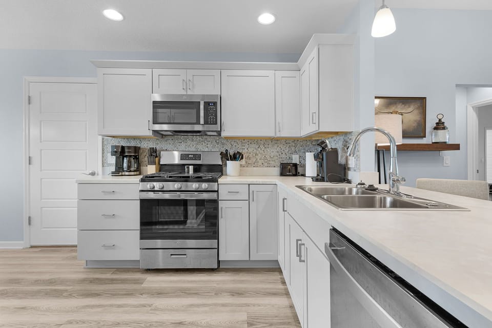 Step into your bright, modern kitchen with clean white cabinetry and gleaming countertops. You'll love cooking with stainless steel appliances and ample counter space for meal prep.