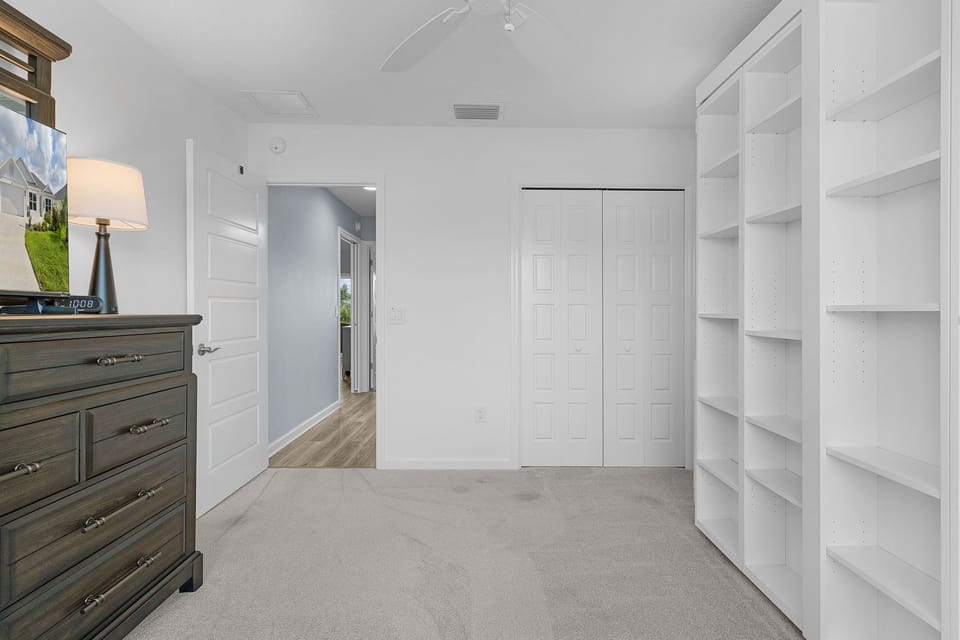 Ample storage awaits with your spacious walk-in closet featuring custom built-in shelving and a bright, organized design for all your belongings.