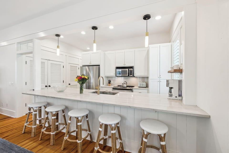 Your spacious kitchen features gleaming white cabinets, quartz countertops, and a breakfast bar where you'll enjoy morning coffee.