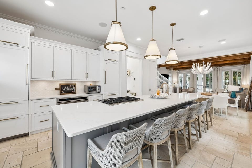 Gather around the spacious island where gleaming countertops and modern appliances invite you to cook and share meals. This bright, open kitchen flows seamlessly into inviting living spaces perfect for your group.
