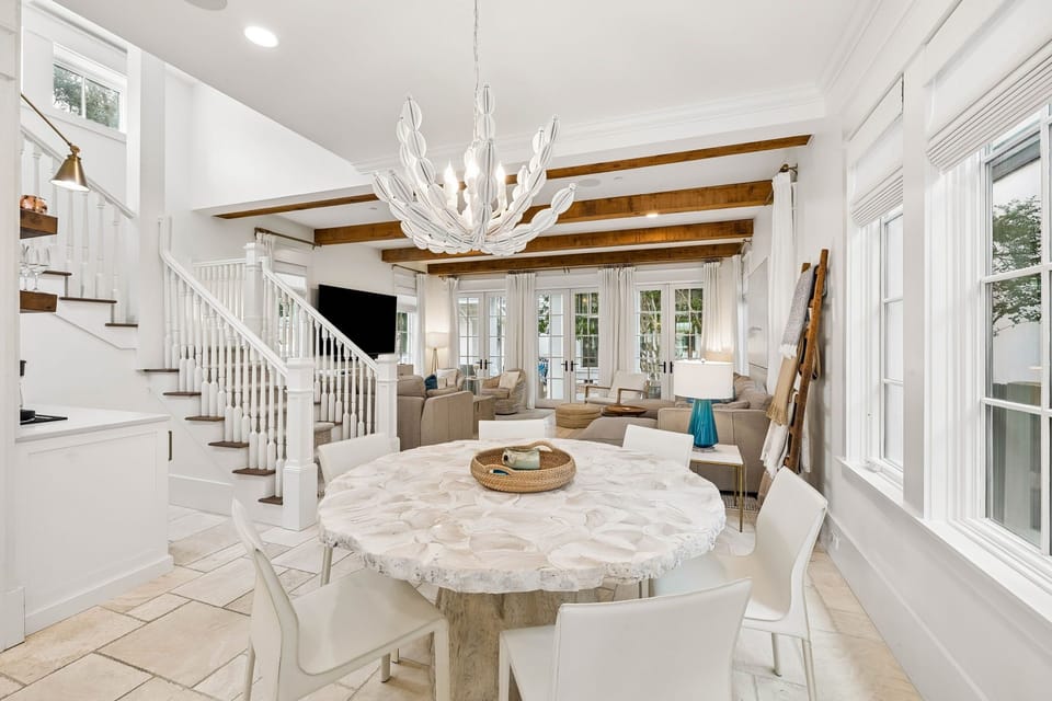 Picture yourself unwinding in this bright, airy space where coastal elegance meets comfort. The soaring beamed ceilings, stunning chandelier, and inviting seating create your perfect retreat for relaxing or gathering with loved ones.