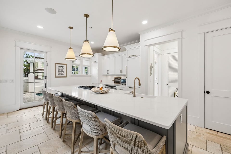 Gather around this spacious kitchen island with seating for six, perfect for preparing meals together or enjoying morning coffee as natural light pours through surrounding windows.