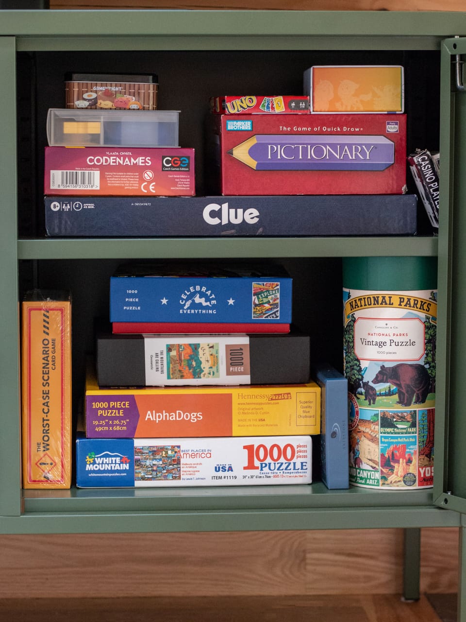 Game cabinet stocked with classic board games and puzzles for cozy nights in