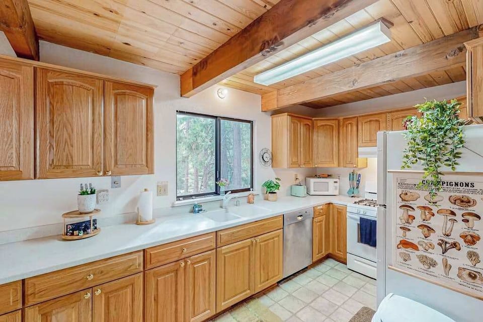 Kitchen at Forest Retreat, where rustic decor meets spacious counters, offering serene forest views of Arnold, CA while you prepare meals.