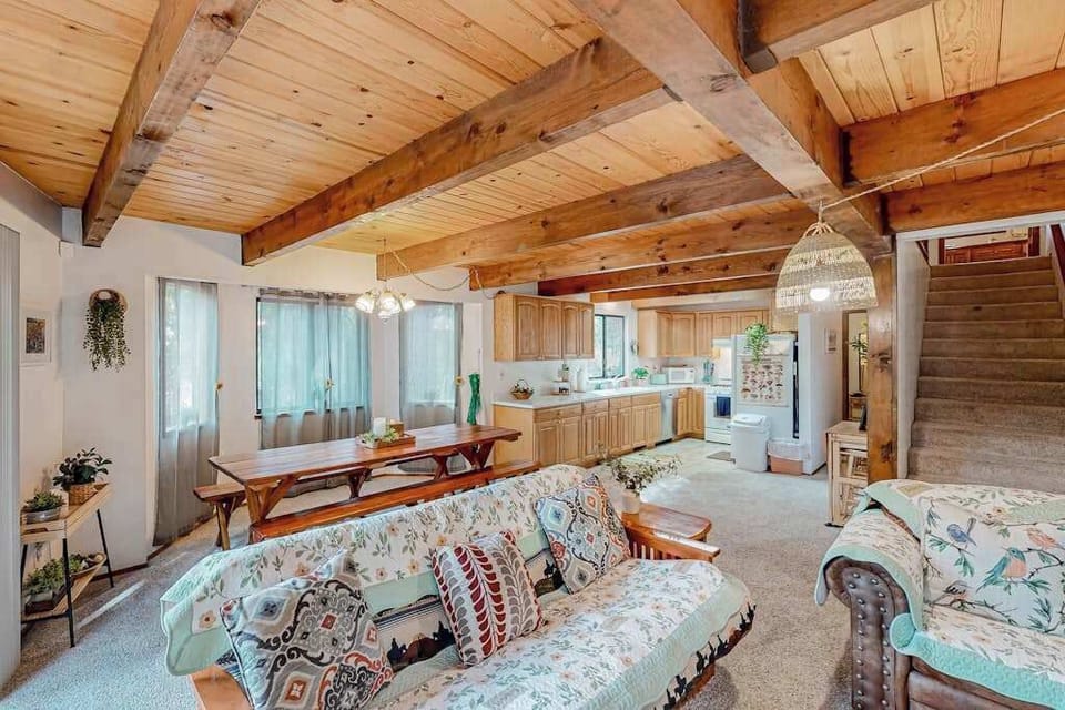 The spacious living room at Forest Retreat, nestled in Arnold, CA, features rustic decor and a comfortable sleeper sofa, perfect for cozy evenings.