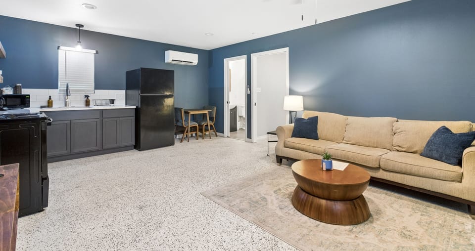 Open living space with cozy sofa, full kitchen, and modern blue accents